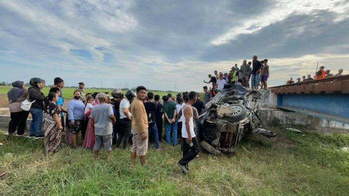TERTABRAK KERETA API: Mobil Daihatsu Xenia yang ditumpangi korban terjatuh di bawah jembatan setelah tertabrak kereta api di Desa Sukamandi Hulu Kecamatan Pagar Merbau Kabupaten Deli Serdang, Rabu (11/6/2025). Dalam peristiwa ini ada dua orang korban yang meninggal dunia.