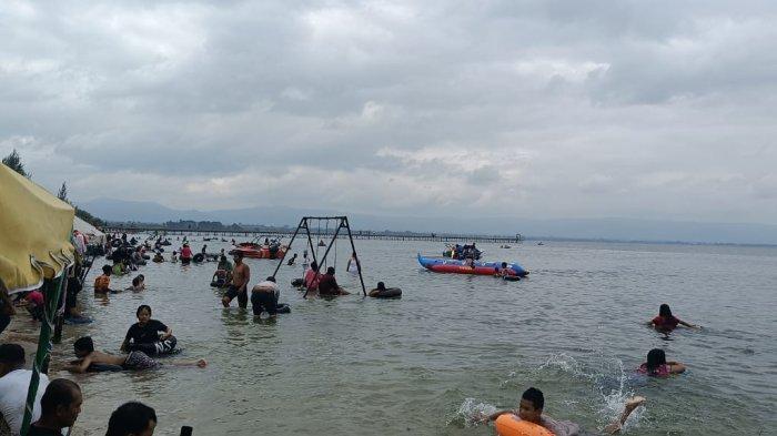 Suasana para pengunjung saat berada di Pantai Pasir Putih Parparean. Pengunjung mengambil aktivitas masing-masing saat berada di lokasi tersebut.