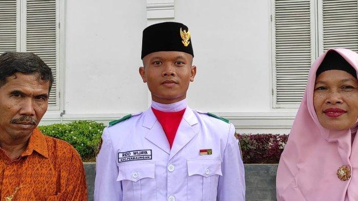 Pelajar Kelas XII SMK Nusantara Angkasa Maritim Sergai, Rido Wijaya didampingi orangtua seusai dikukuhkan sebagai anggota paskibraka Sergai