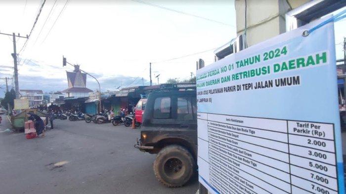 Pengendara melintas di salah satu titik pemasangan baliho yang berisikan sosialisasi terkait perubahan tarif parkir dari Dishub Kabupaten Karo, di kawasan Pusat Pasar Kabanjahe, Rabu (10/1/2024). (TRIBUN MEDAN/MUHAMMAD NASRUL)