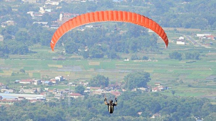 
Pengunjung bermain paralayang di Dataran tinggi Sibodiala yangmerupakan tempat wisata di Balige yang cukup populer. 