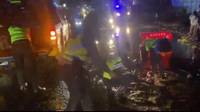 Personel Polres Tanah Karo melakukan penutupan jalan yang berlubang di Jalan Jamin Ginting, Desa Raya, Berastagi, menggunakan bongkahan batu, Jumat (29/12/2023). Akibat adanya lubang yang tergenang banjir di ruas jalan ini, sempat menimbulkan kemacetan di jalur lintas Berastagi-Kabanjahe.