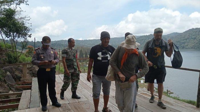 Personel Polsek Simpang Empat mengarahkan tiga WNA yang coba mendaki ke Gunung Sinabung untuk kembali pulang, saat ditemukan di kawasan bukit Lau Kawar, Jumat (23/2/2024).