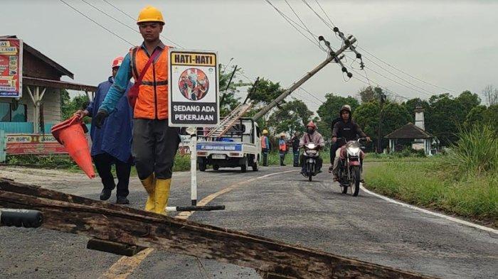 Petugas PLN Kabanjahe memasang tanda sedang ada pengerjaan karena adanya tiang listrik yang tumbang akibat cuaca buruk, di kawasan Desa Kacaribu, Kecamatan Kabanjahe, belum lama ini.