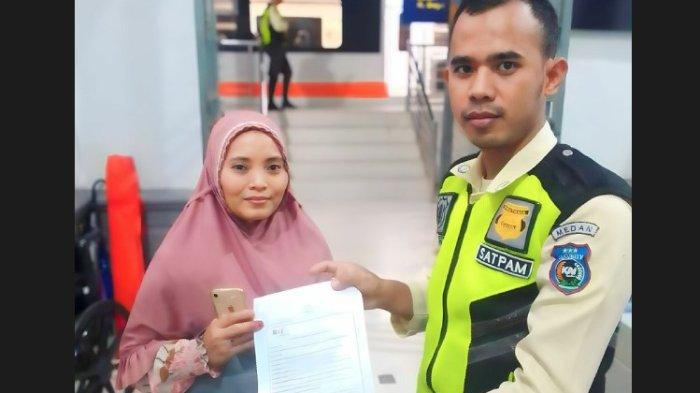Petugas petugas KAI Bandara bernama Fuji Alwi saat menyerahkan tas yang berisikan uang Rp 14 juta ke petugas keaamanan Stasiun Binjai, Kamis (15/2/2024).