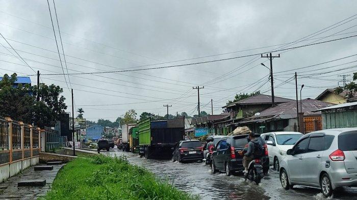 Puluhan kendaraan melintasi jalur Jalan Jamin Ginting, tepatnya di kawasan Desa Raya, Berastagi, yang tergenang banjir karena diguyur hujan sejak pagi, Minggu (29/10/2023).