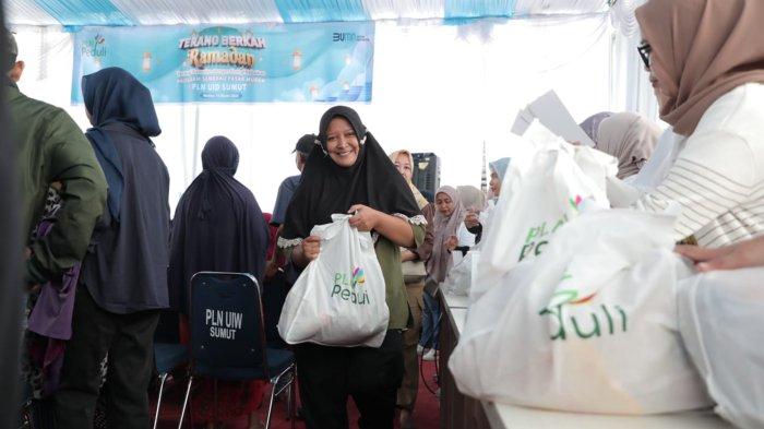 Senyum seorang Ibu Rumah Tangga yang sudah berhasil mendapatkan sembako 