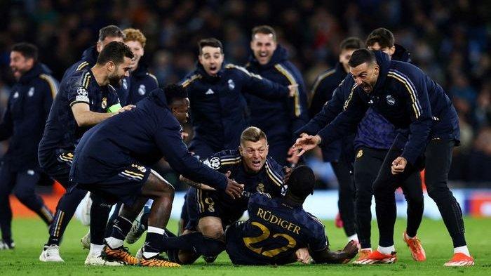 Antonio Ruediger (bawah) diserbu rekan setim usai menentukan kelolosan Real Madrid dalam adu penalti lawan Man City pada perempat final Liga Champions di Etihad Stadium (16/4/2024).