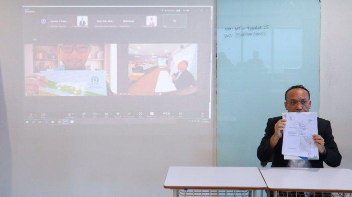 Rektor Universitas MTU, Dr. Dompak Pasaribu, SE., M.Si., CPA., CACP menunjukkan MoU usai melakukan penandatangan melalui zoom, Jumat (17/10/2024).
