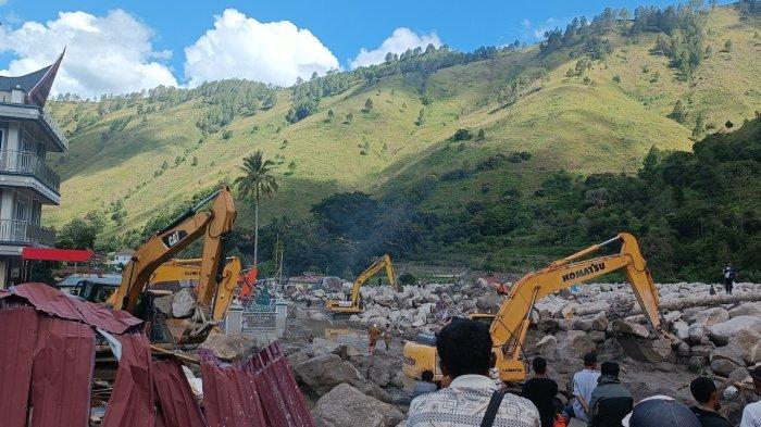Sejumlah alat berat berada di lokasi banjir bandang di Desa Simangulampe, Kecamatan Baktiraja, Kabupaten Humbang Hasundutan, Senin (4/12/2023). Sejumlah warga sekitar dan keluarga korban juga menyaksikan proses pencarian orang hilang dan pembersihan material longsoran.