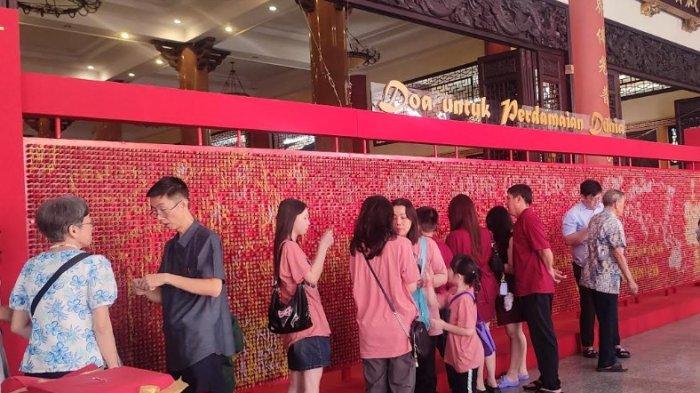 PERAYAAN IMLEK - Sejumlah masyarakat  etnis Tionghoa saat menyampaikan doa perdamaian untuk dunia di puzzle harapan  Vihara Maitreya, Rabu (29/1/2025). Di vihara ini juga terdapat banyak spot foto yang instagramable.