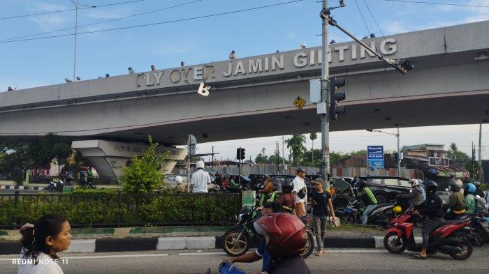 JATUH DARI FLY OVER - Sejumlah warga memadati lokasi tewasnya seorang pria paruh baya setelah terjatuh dari Fly Over Jalan Jamin Ginting, Kelurahan Kwala Bekala, Kecamatan Medan Johor, Kota Medan, Jumat (11/7/2025).