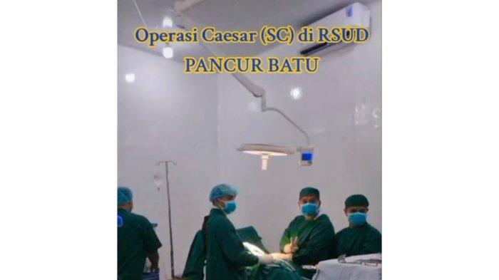 Salah satu dokter Obgyn mengacungkan tanda dua jari di sela-sela operasi di RSUD Pancur Batu, beberapa waktu lalu