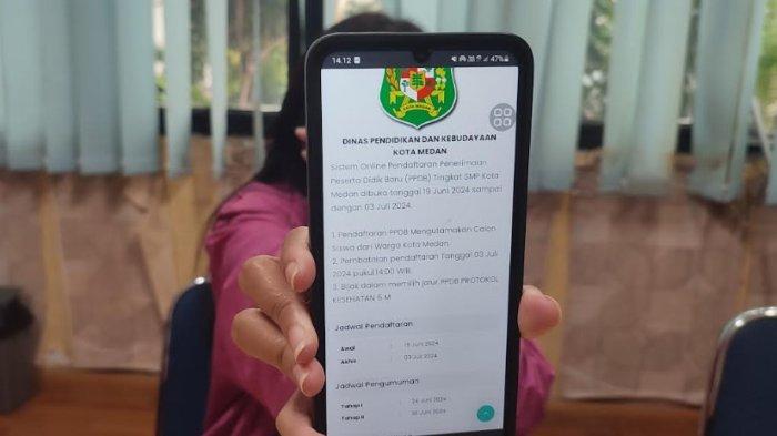 Seorang wali murid sedang mencoba membuka PPDB Pemko Medan,Senin (1/7/2024). Pendaftaran ulang PPDB dilakukan mulai hari ini secara offline ke sekolah masing-masing.