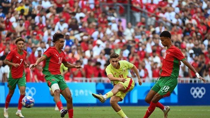 Pemain timnas Spanyol, Fermin Lopez (tengah) melepaskan tembakan di antara para pemain timnas Maroko pada semifinal Olimpiade 2024 di Stade de Marseille (5/8/2024).