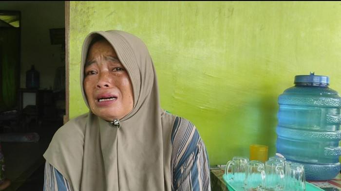 Sriana (42) istri dari Iman Kurnia Abadi (45) tukang ojek pangkalan yang diduga tewas akibat dibegal di Jalan Yos Sudarso, depan Gang Taik, Kelurahan Belawan Bahari Kecamatan Medan Belawan, ketika diwawancarai, Rabu (30/7/2025). Ia tak kuasa membendung air matanya saat menceritakan kepedihan hatinya karena sang suami meninggal tragis.