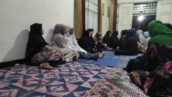 Suasana duka menyelimuti Tina (mukena putih), ibu dari personel Polres Dairi berinisial Bripda F, yang diduga mengakhiri hidupnya di ruang kerja, Senin (13/1/2025). Tina, tampak lemas duduk beralas tikar, bersandar ke dinding.