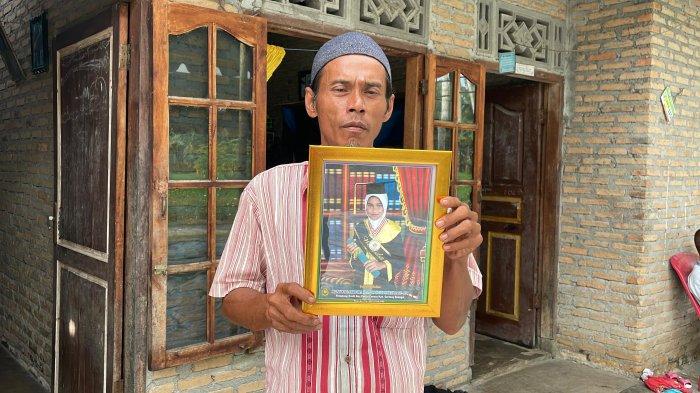 Supardi Harefa menunjukkan foto almarhum anaknya semasa hidup, Senin (16/12/2024).