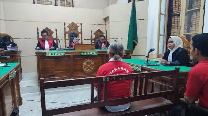 DOSEN BUNUH SUAMI: Terdakwa Tiromsi Sitanggang saat mendengarkan hakim dalam sidang lanjutan pembunuhan yang dia lakukan terhadap suaminya berlangsung di Pengadilan Negeri Medan, Senin (8/7/2025).