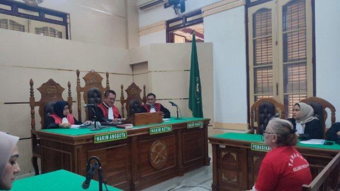 DOSEN BUNUH SUAMI: Terdakwa Tiromsi Sitanggang saat mendengarkan hakim setelah mendengarkan keterangan saksi pada sidang lanjutan pembunuhan yang dia lakukan terhadap suaminya berlangsung di Pengadilan Negeri Medan, Senin (5/5/2025). /ANUGRAH NASUTION.