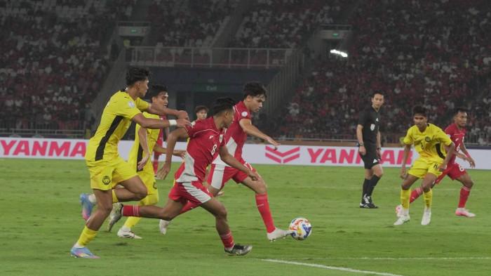 IMBANG - Aksi pemain Timnas U23 Indonesia saat melewati pemain Malaysia U23 pada laga terkahir penyisihan Grup A Piala AFF U23 2025 di Stadion Utama Gelora Bung Karno, Senin (21/7/2025). Dalam laga ini Timnas U23 Indonesia ditahan imbang Malaysia 0-0, dan membuat Garuda Muda lolos semifinal. Sementara Malaysia tersingkir