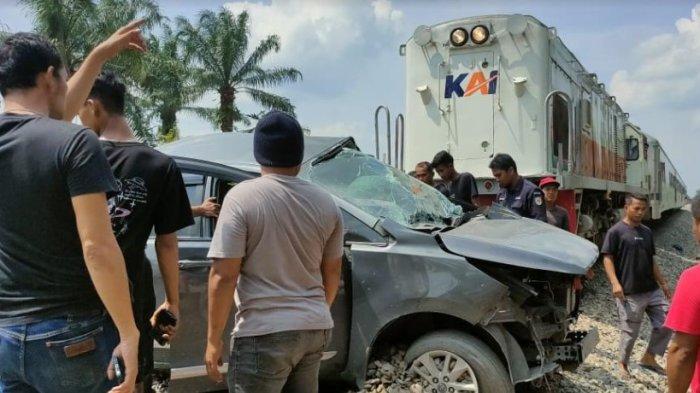Warga saat melakukan evakuasi Lakalantas mini bus jenis Inova Reborn Vs Kereta Api, di perlintasan tanpa palang pintu, di Jalan Abdul Hamid, Kecamatan Padang Hilir, Kota Tebingtinggi, Minggu (14/1/2024).