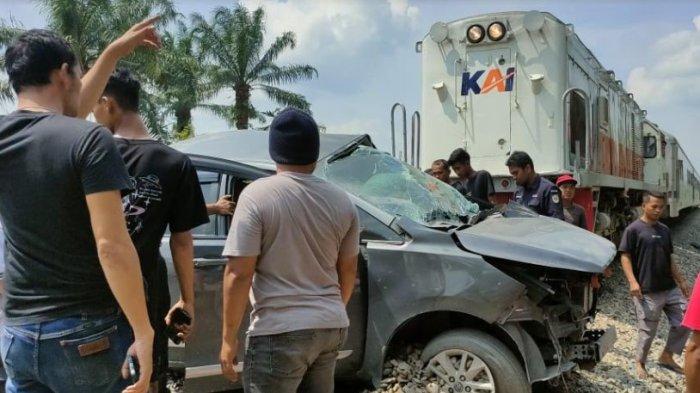 Warga saat melakukan evakuasi Lakalantas mini bus jenis Inova Reborn Vs Kereta Api, di perlintasan tanpa palang pintu, di Jalan Abdul Hamid, Kecamatan Padang Hilir, Kota Tebingtinggi, Minggu (14/1/2024).