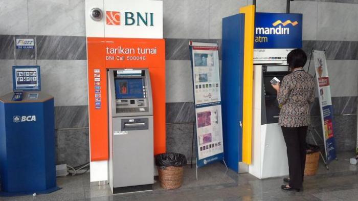 Nasabah melakukan transaksi dengan mesin ATM.