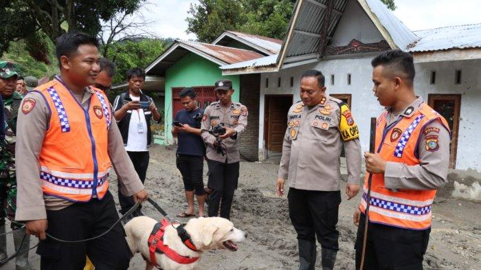 Personel Polda Sumut menmbawa anjin pelacak saat mencari 11 warga yang hilang akibat bencana alam tanah longsor yang terjadi di Dusun III, Desa Simangulampe, Kecamatan Bakti Raja, Kabupaten Humbang Hasundutan (Humbahas), Minggu (3/12/2023)