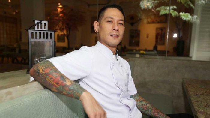 Chef Juna menunjukkan tato di tubuhnya saat berpose di Restoran Correlate, Kuningan, Jakarta