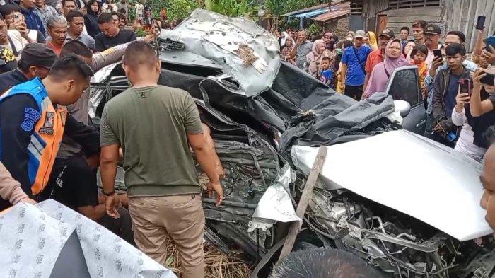 Warga mengevakuasi korban yang terjepit didalam minibus Nisan Juke Silver ringsek dihantam kereta api diperlintasan kereta tanpa plang di Jalan Marah Rusli, Kelurahan Selawan, Kecamatan Kota Kisaran Timur, Kabupaten Asahan. (Alif Alqadri Harahap / Tribun-Medan.com)
