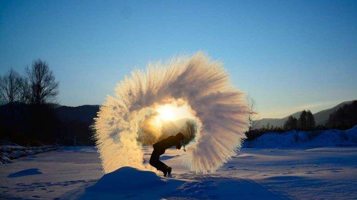 Air panas memercik dari botol termos dan langsung berubah menjadi es di bawah suhu dingin yang ekstrim di Changchun, Provinsi Jilin.
