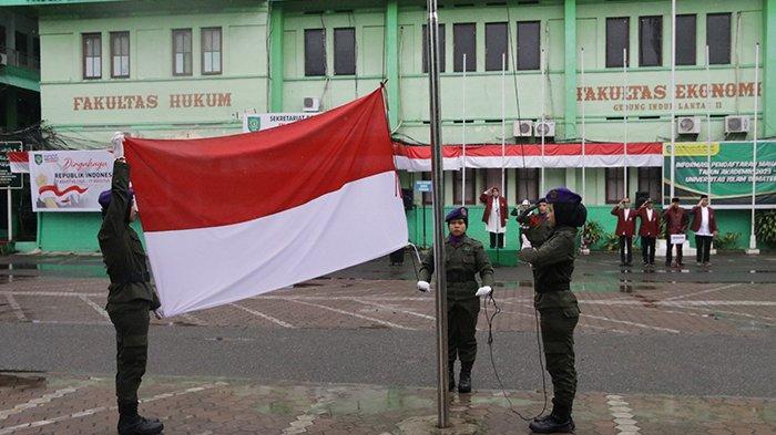 Petugas pengibar bendera sedang mengibarkan bendera merah putih saat Upacara Peringatan HUT RI-78 yang dipimpin Rektor UISU Dr. Safrida SE, M.Si di lapangan Parkir Kampus UISU Jalan SM Raja Medan, Kamis (17/8)