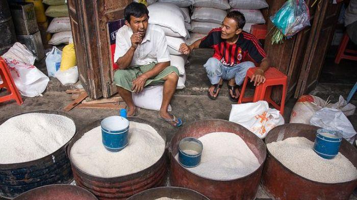 PEDAGANG BERAS- Foto seorang pedagang beras yang tengah menunggu pembeli di kios miliknya.