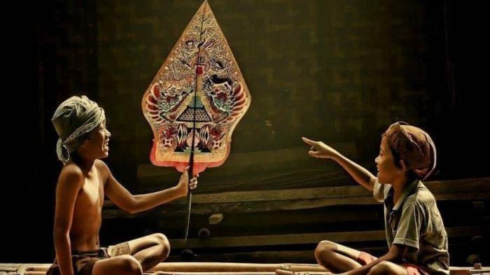 WAYANG KULIT- Dua orang bocah sedang asyik bermain wayang kulit. Wayang merupakan budaya tradisional suku Jawa.