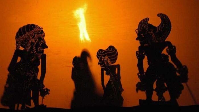 PEMENTASAN WAYANG- Ilustrasi pementasan wayang yang disinari dengan cahaya obor.