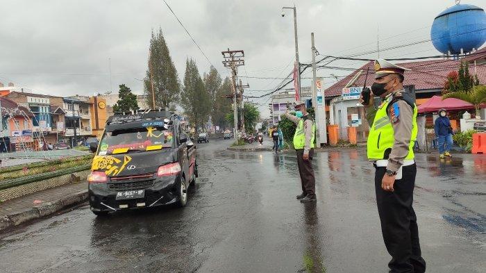 Personel Unit Lantas Polsekta Berastagi, melakukan pengaturan arus lalulintas di seputar Tugu Perjuangan, Berastagi, Minggu (6/3/2022). (TRIBUN MEDAN/MUHAMMAD NASRUL)