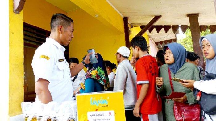 Sejumlah masyarakat sedang mengantre untuk membeli kebutuhan bahan pokok di mobil pasar murah keliling beberapa waktu lalu.  