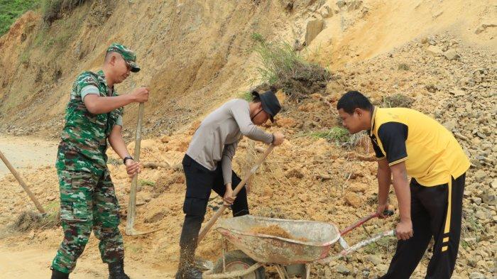 Samapta Polres Samosir gotongroyong membersihkan material longsor material longsor yang didapati menutupi badan Jalan Umum yang menghubungkan Kenegerian Harian dan Kenegerian Sihotang Kecamatan Harian Kabupaten Samosir, Jumat (1/9/2023).