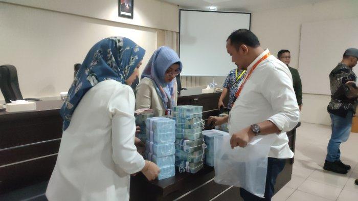 Petugas menghitung uang yang dikembalikan tiga kontraktor Lansekap Lampu Hias atau dikenal warga net dengan proyek lampu pocong, Jumat (29/12/2023). Wali Kota Medan Bobby Nasution menyebutkan uang yang dikembalikan ketiga kontraktor itu sebesar Rp 7,8 miliar.