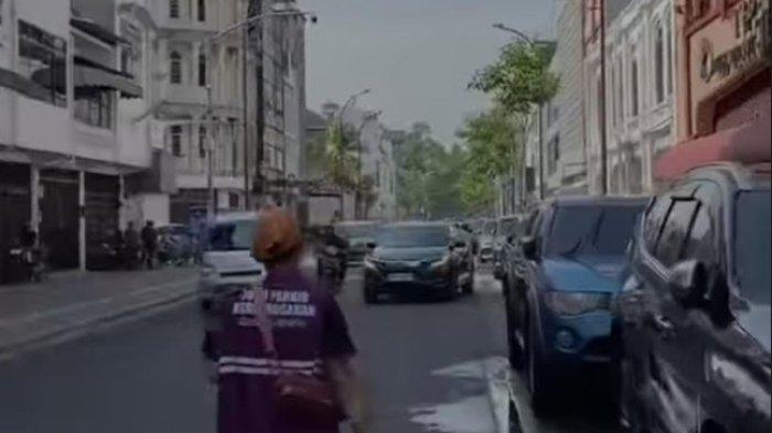 seorang jukir berlangganan sedang mengecek barcode stiker parkir berlangganan di Jalan Kesawan Kota Medan, Kamis (8/8/2024). Kadishub Medan Iswar ancam tak turunkan gaji jukir berlangganan, apabila  masih melakukan pengutipan uang parkir