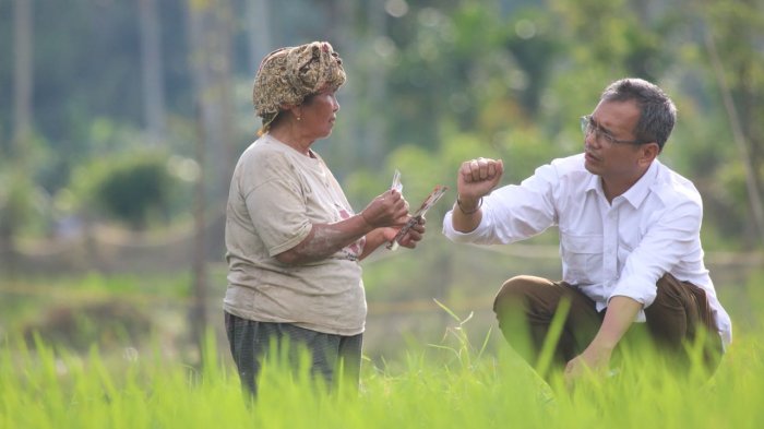 Sihar PH Sitorus saat berbincang-bincang dengan seorang ibu di pinggir sawah beberapa waktu lalu.