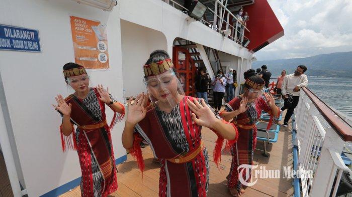 Sejumlah penari menampilkan tarian Tor-Tor di atas kapal Ihan Batak saat menyeberang dari pulau Samosir menuju pelabuhan Ajibata, Parapat, Sumatera Utara, Sabtu (24/10/2020). Tari Tor Tor merupakan tarian sakral suku Batak, namun saat ini tari Tor Tor dikemas sebagai salah satu daya tarik wisata budaya.TRIBUN MEDAN/RISKI CAHYADI