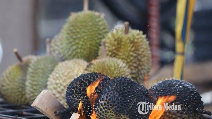 Pedagang mempersiapkan durian bakar pesanan dari pembeli di Jalan Bromo, Medan, Sumatera Utara, Jumat (27/8/2021). Buah durian yang menjadi salah satu primadona yang disantap dengan cara dibakar itu dijual dengan harga Rp25.000-Rp50.000 per butir.TRIBUN MEDAN/RISKI CAHYADI