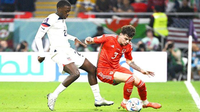 Pemain Tim Nasional Amerika Serikat Timothy Weah (kiri belakang) mencoba membayang-bayangi pemain Tim Nasional Wales Neco Williams pada laga Grup B Piala Dunia 2022 yang digelar di Ahmad Bin Ali Stadium di Al-Rayyan, Doha, Qatar, 21  November 2022. Weah yang merupakan putra Presiden Liberia yang juga merupakan legenda sepak bola dunia George Weah akan menjadi andalan Amerika Serikat 