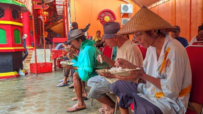 MAKAN ENAK GRATIS: Warga menikmati makan siang enak gratis di Kelenteng Hok Tik Bio Pati, Selasa (28/1/2025). Makan enak gratis ini merupakan bagian dari perayaan Imlek di klenteng tersebut. (TribunMuria.com/Mazka Hauzan Naufal)
