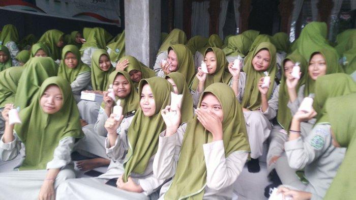 Santri Assa'idiyyah Kudus menunjukkan susu kemasan siap minum dalam gerakan makan siang dan minum susu serentak, Rabu (29/11/2023).