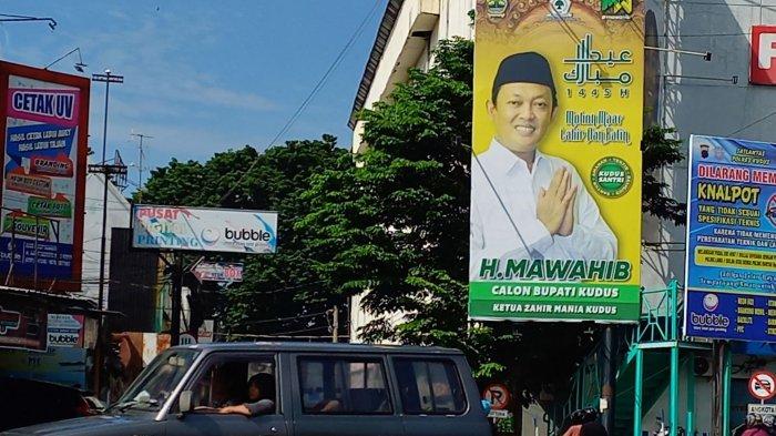 Baliho bergambar Mawahib terpasang di sudut utara Alun-alun Simpang Tujuh Kudus. Mawahib mengaku mantab maju bertarung pada Pilkada Kudus 2024 setelah kantongi restu keluarga dan para kiai.