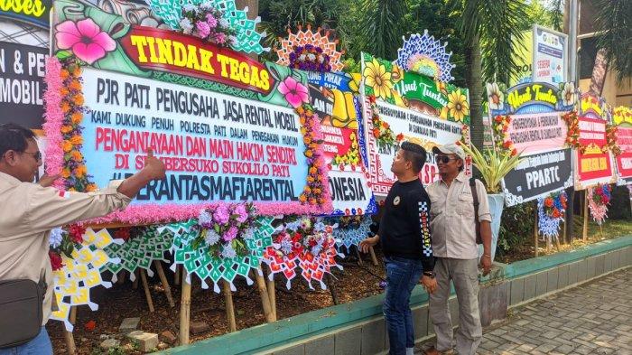 Deretan karangan bunga dari berbagai komunitas pengusaha rental mobil di halaman Mapolresta Pati, Senin (10/6/2024).