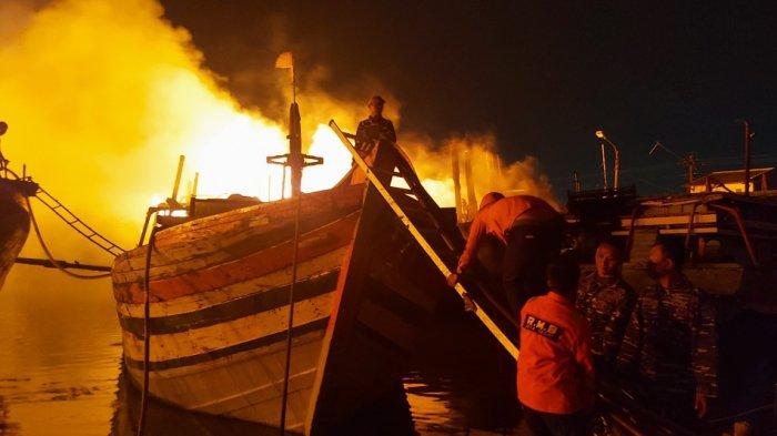 Petugas berusaha memadamkan api di Pelabuhan Perikanan Pantai (PPP) Tegalsari atau lebih dikenal Pelabuhan Jongor Tegal, Senin (14/8/2023).